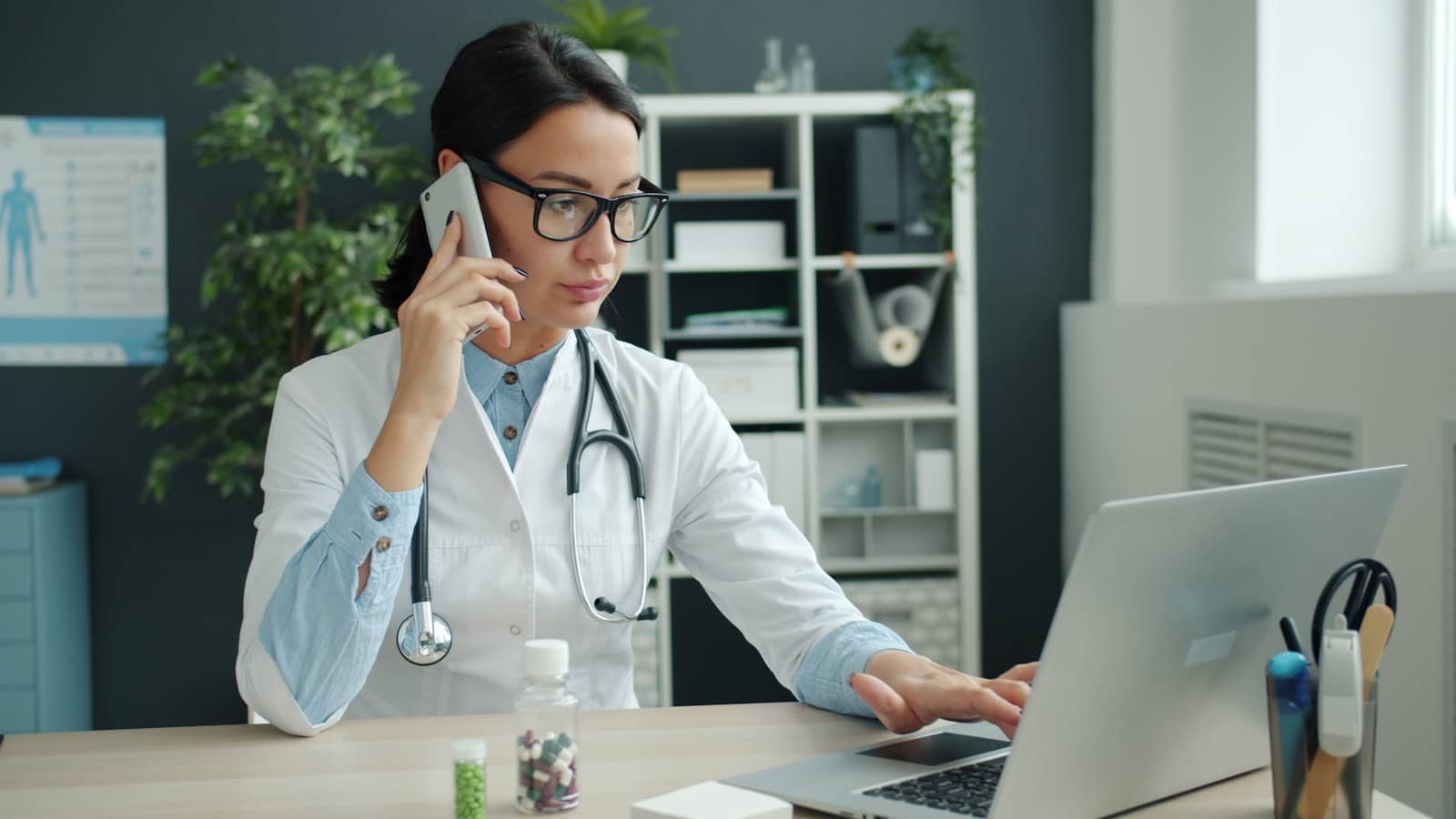 Médica analisando resultados de marketing de conteúdo no laptop do consultório