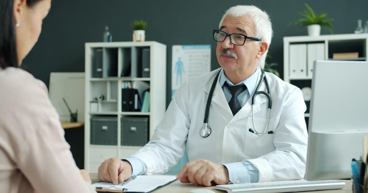Médico especialista e paciente selando acordo de consulta particular em consultório moderno